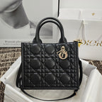 Black quilted handbag with top handles and gold logo charm hardware