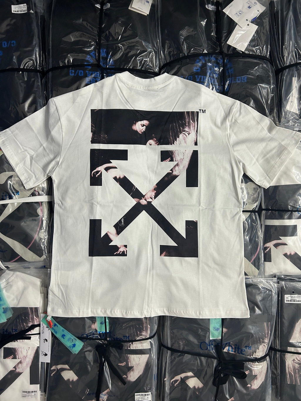 Off-white T-shirt with large black graphic and crossed arrow design on front