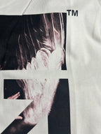 Off-white T-shirt close-up showing black-and-white graphic panel and arrow X