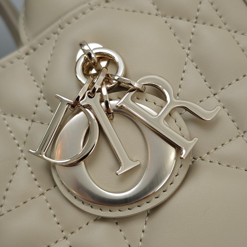 Beige quilted handbag logo charm with metal Dior lettering and clasp