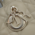 Beige quilted handbag logo charm with metal Dior lettering and clasp