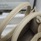 Beige handbag top handles with contrast stitching and reinforced seams