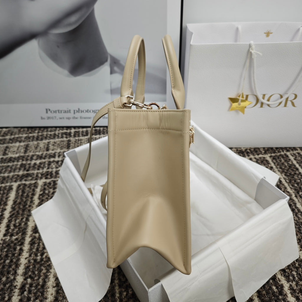 Beige leather handbag with zip top, two handles, and side view