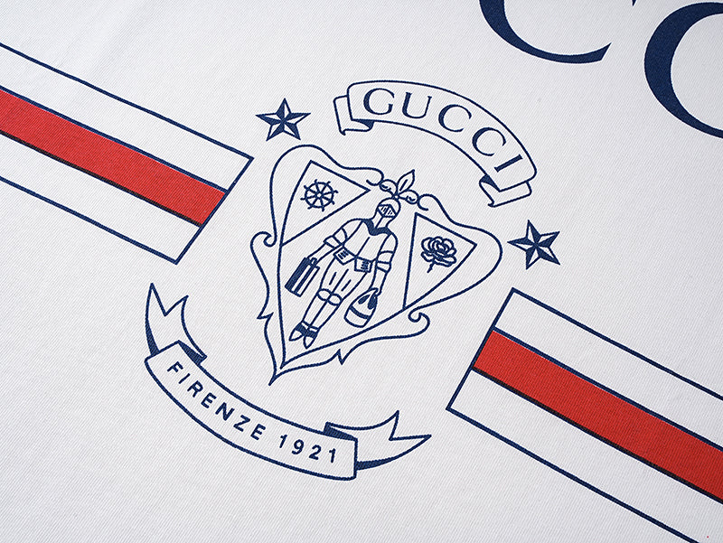 White short-sleeve T-shirt with crest graphic and red, blue, and white stripe accents