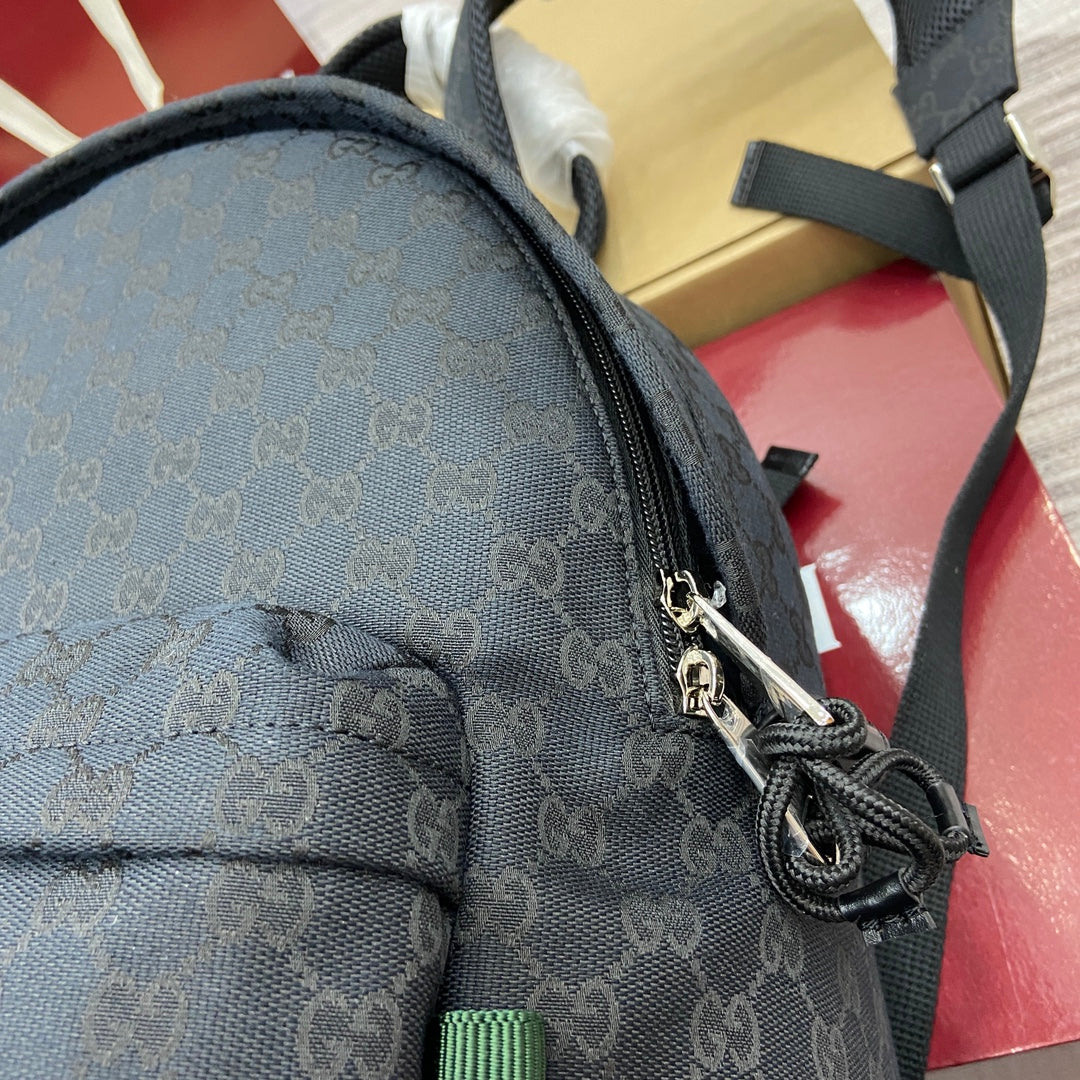 Gucci men's monogram backpack top corner with braided drawstring cord and metal clasp