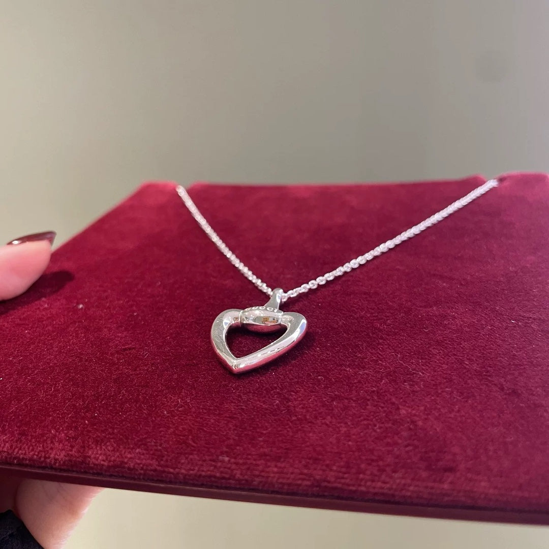 Gucci heart pendant necklace close-up with silver heart charm and dark center