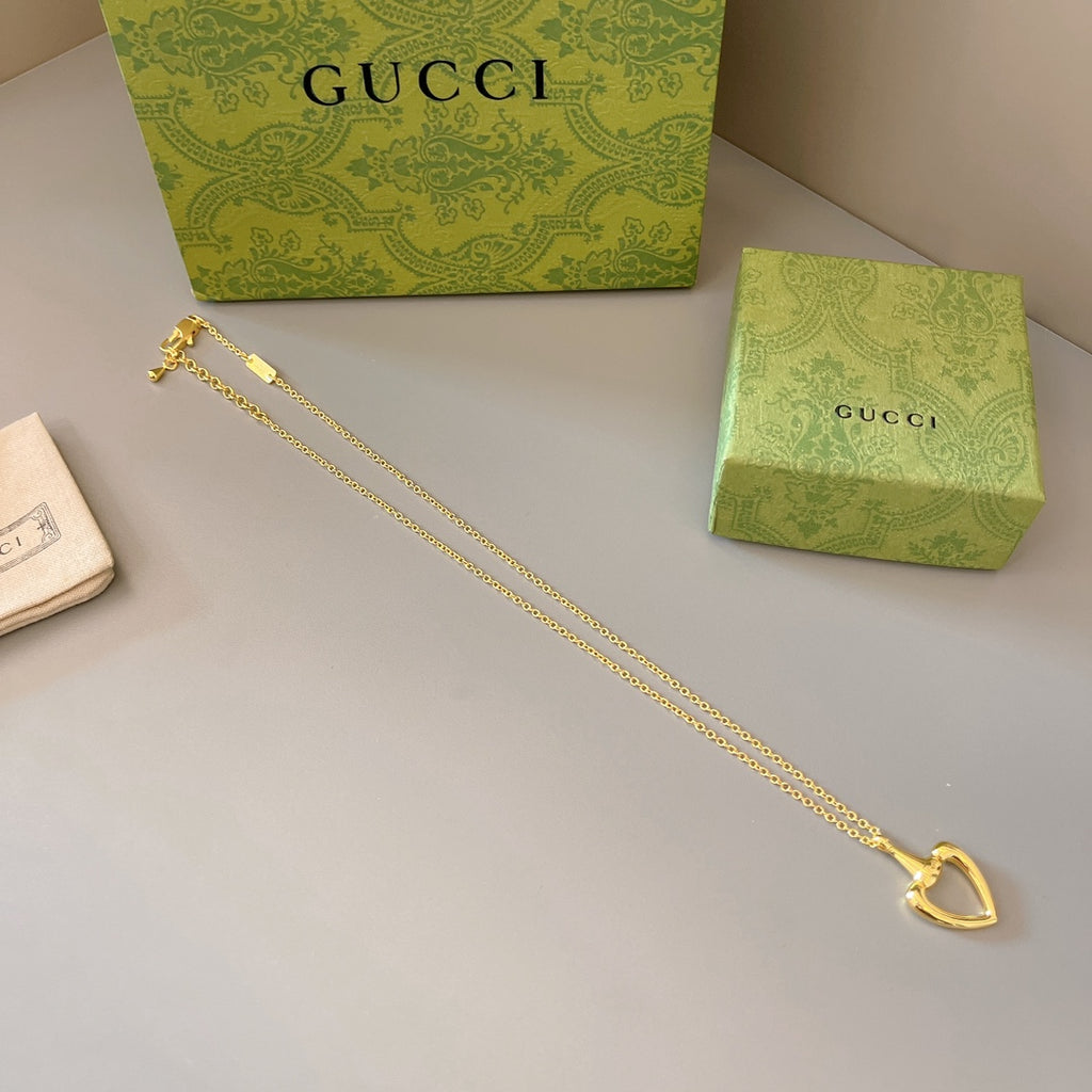 Gold-tone heart pendant necklace with long chain and centered heart charm