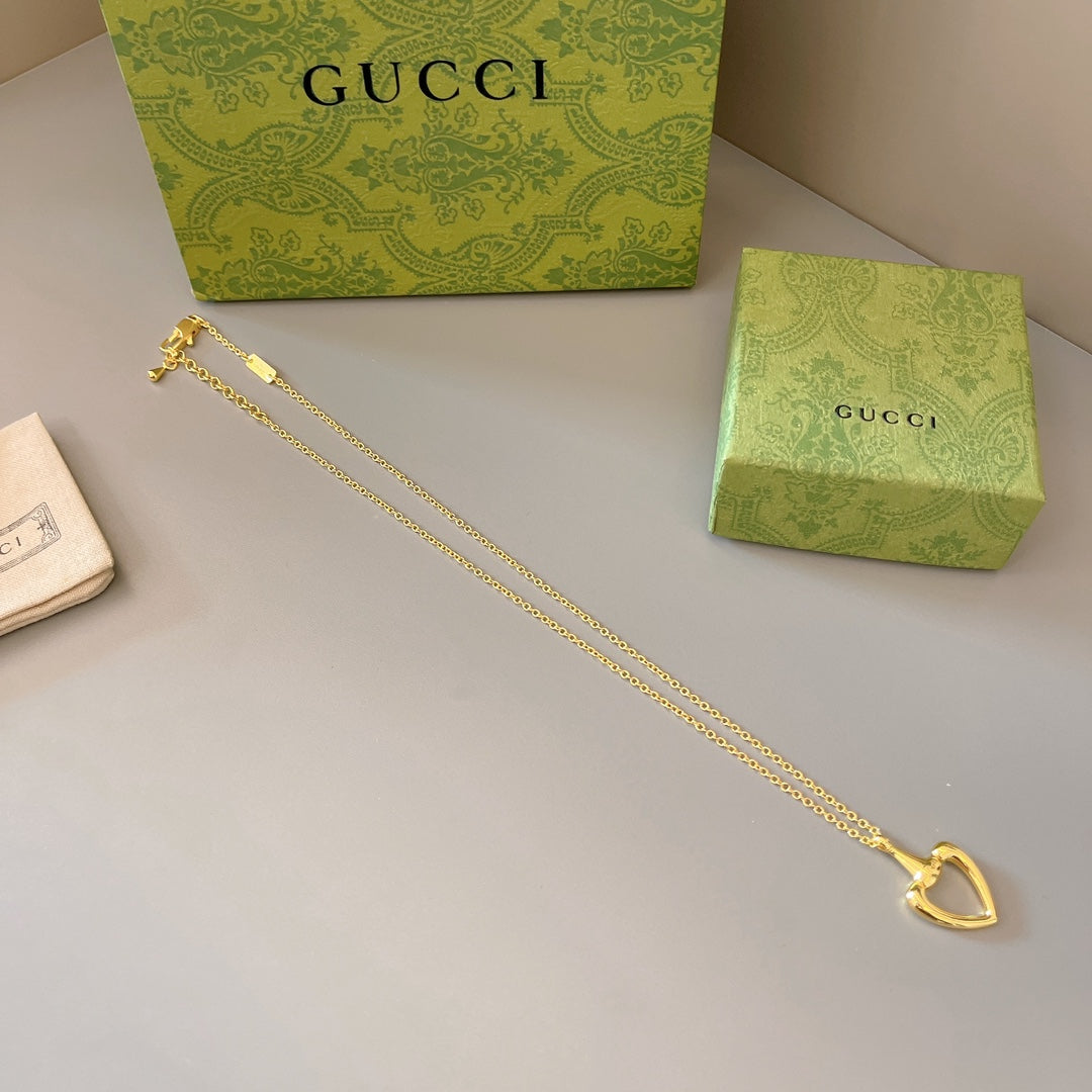 Gold-tone heart pendant necklace with long chain and centered heart charm
