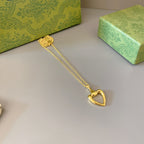 Gold-tone heart pendant necklace with dangling heart charm at the end of the chain