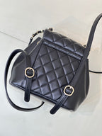 Dark navy quilted leather mini bag with front buckle straps and top handle