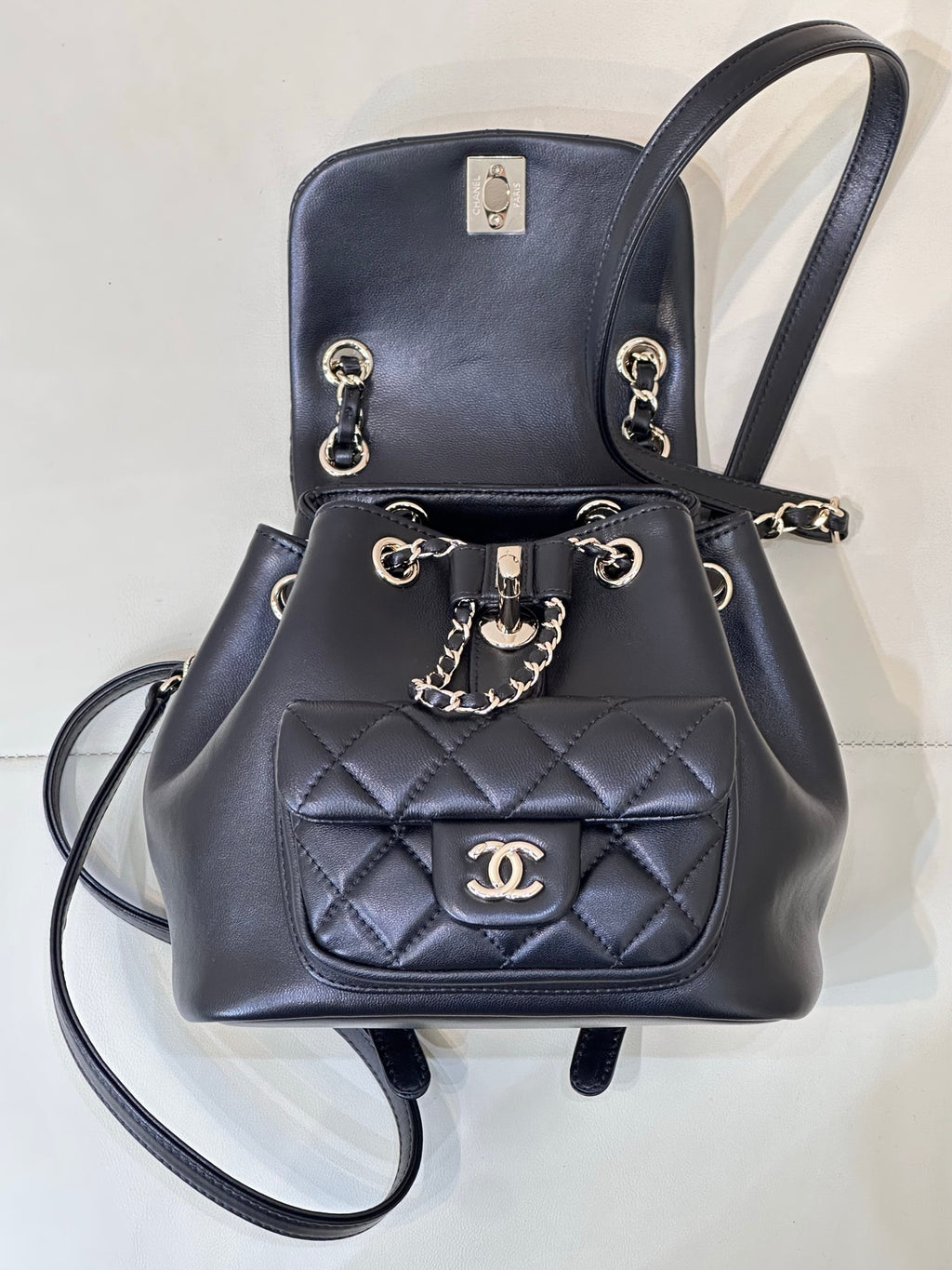 Dark navy quilted leather bag with chain strap and CC logo plaque on front