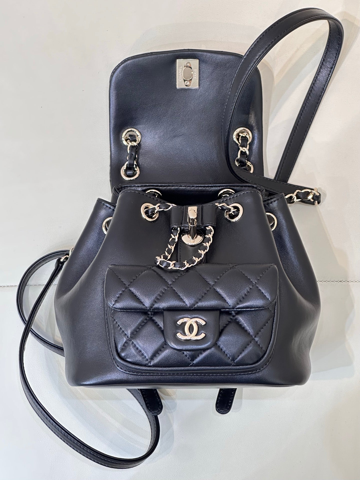 Dark navy quilted leather bag with chain strap and CC logo plaque on front