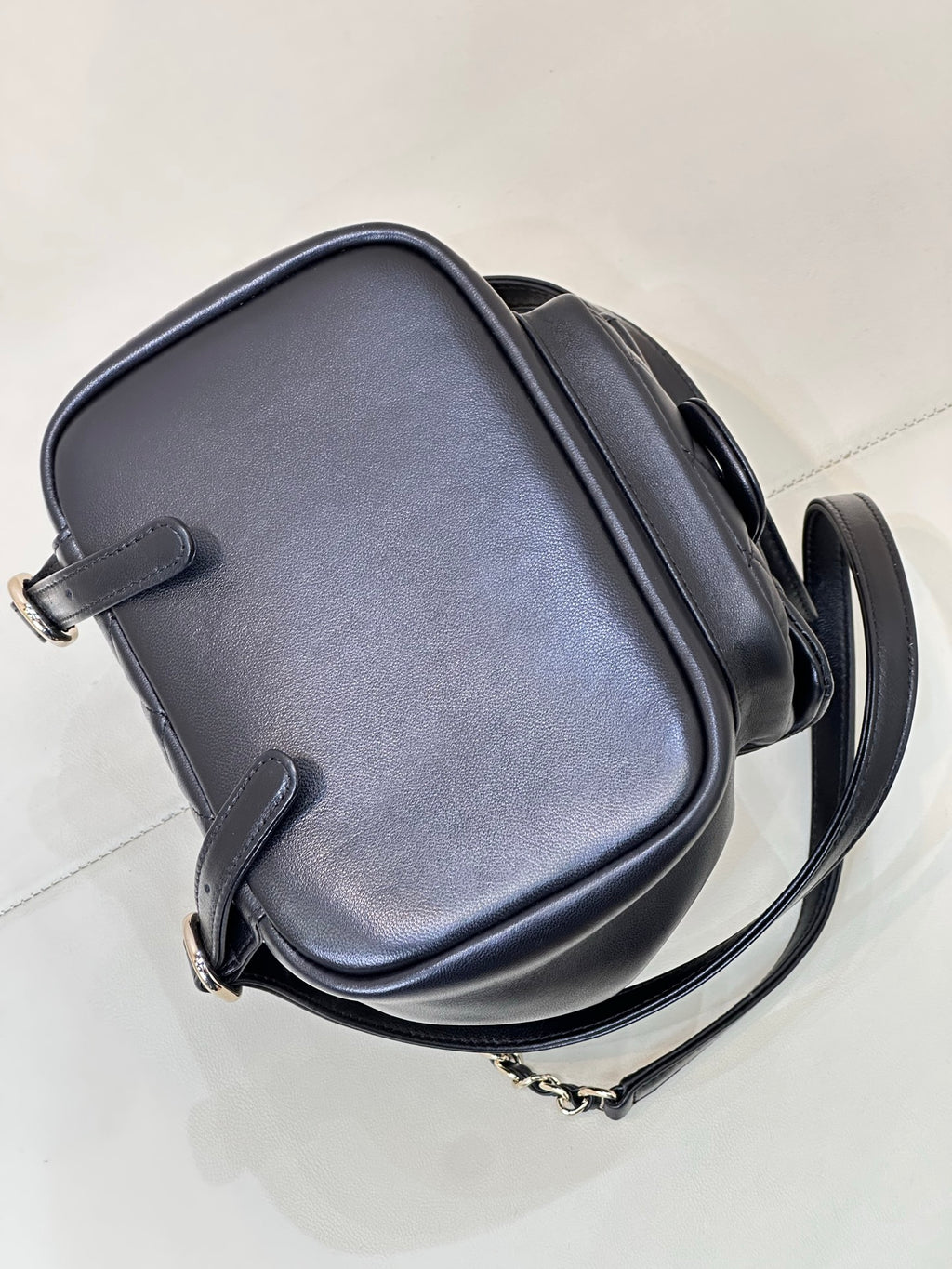 Dark navy leather crossbody bag with curved flap and chain shoulder strap