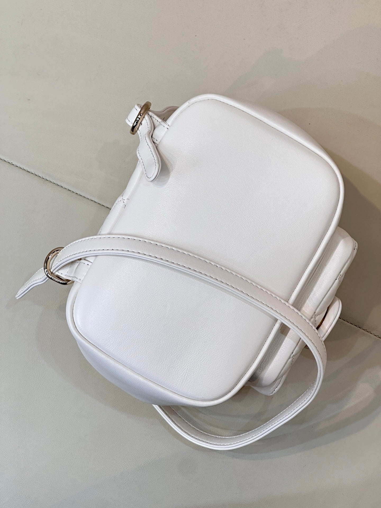 Chanel leather crossbody bag with top zip, rounded silhouette, and small gold-tone pull