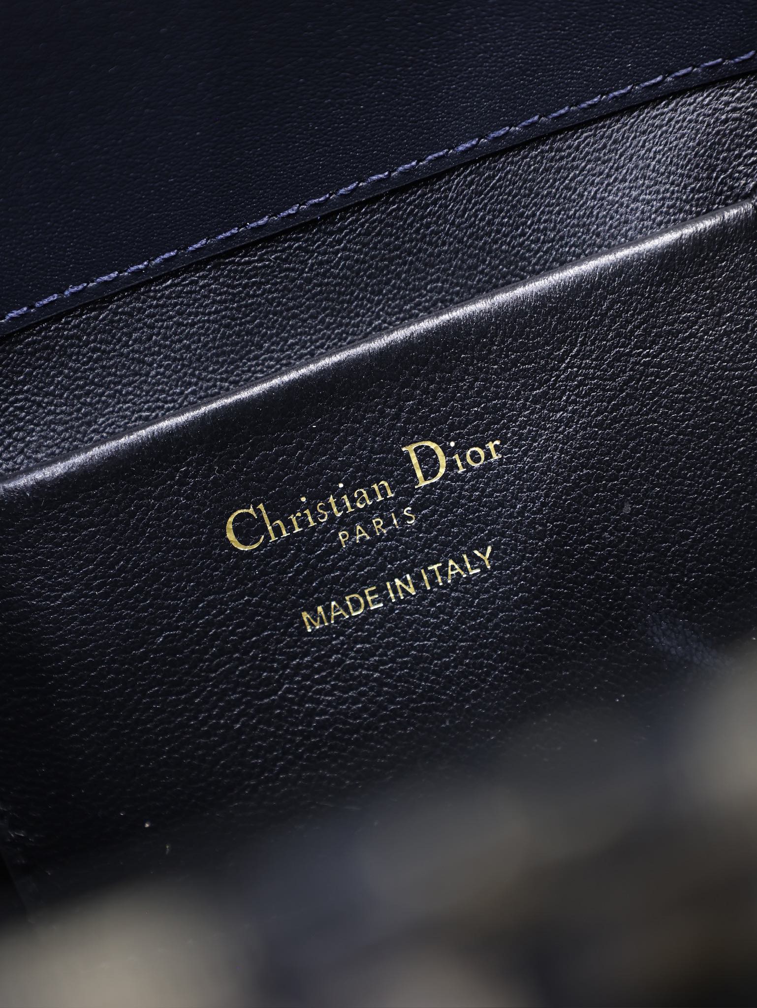 Dior bag interior label with gold "Christian Dior Paris" and "Made in Italy"