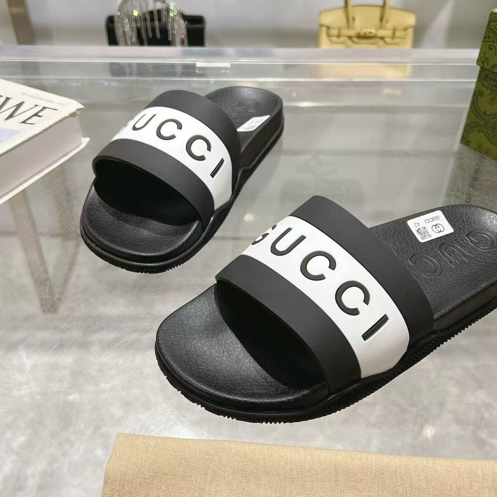 Black Gucci slide sandals with white logo strap, close-up of front and top