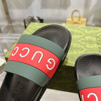 Close-up of black Gucci slide sandal strap with green base and red Gucci band