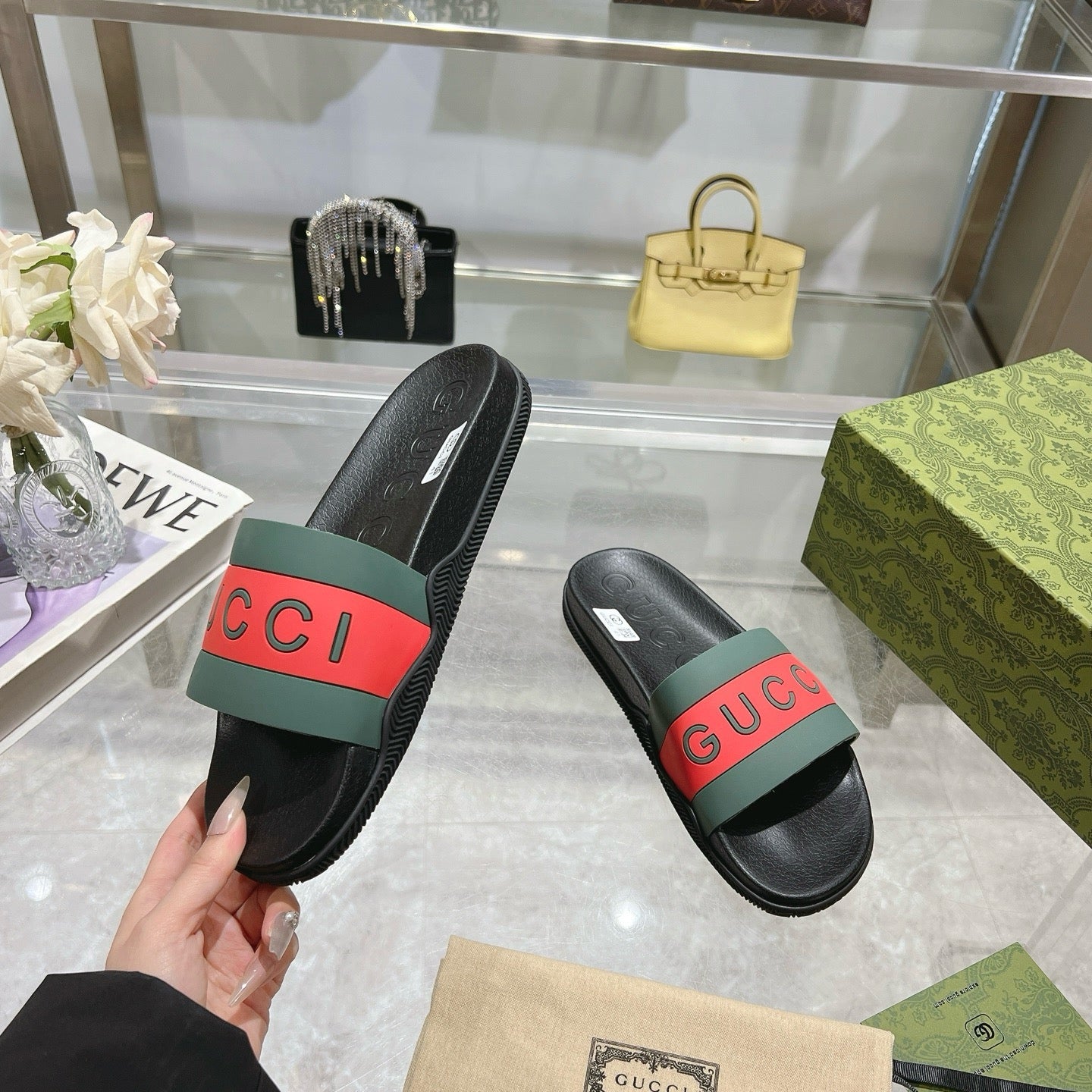 Pair of Gucci slide sandals with black footbeds and green-red logo straps