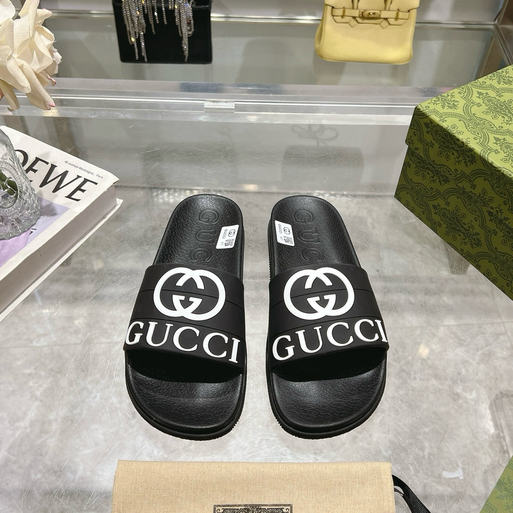Black Gucci slide sandals with wide logo band and textured footbed