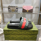 Gucci slide sandals, black footbed with green-red logo strap and molded texture