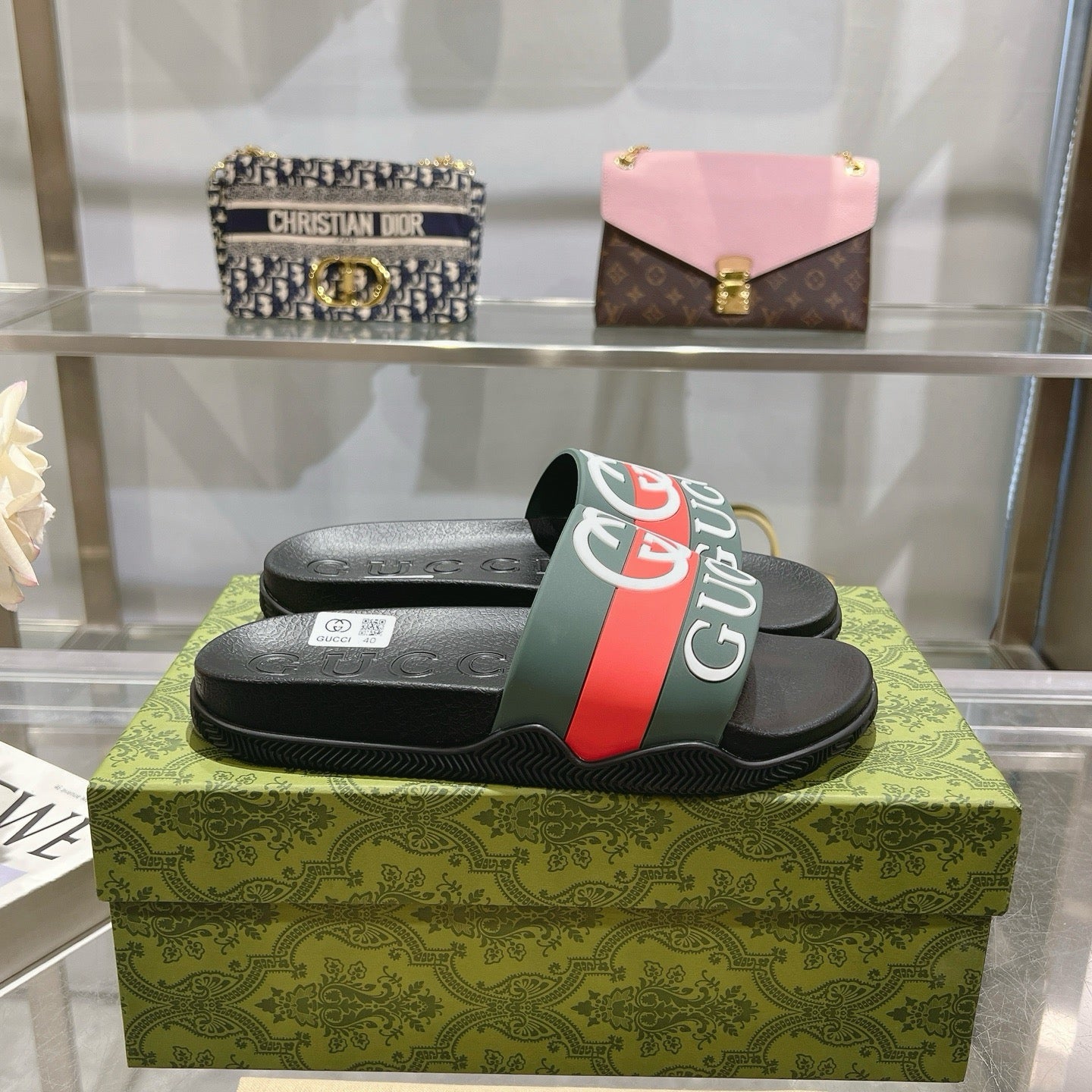 Gucci slide sandals, black footbed with green-red logo strap and molded texture