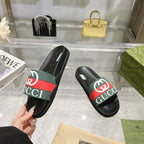 Gucci slide sandals, black slides with green-red logo stripe, side view on hand