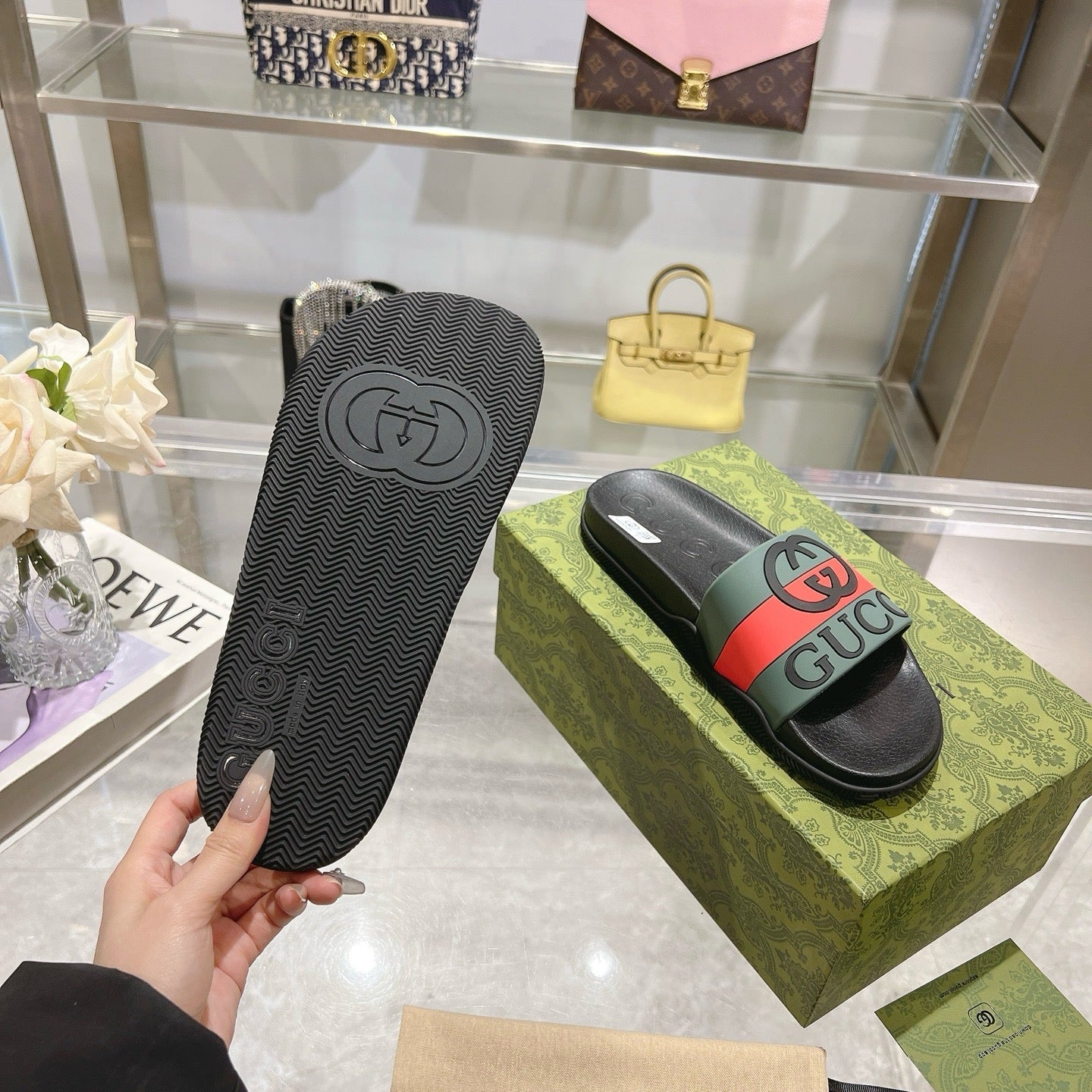 Black Gucci slide sandal outsole with tread pattern and molded logo.