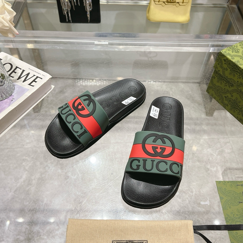Black Gucci slide sandals with green-and-red striped strap and textured footbed.