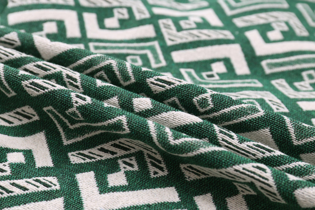 Green fabric with white geometric motif, textured weave close-up