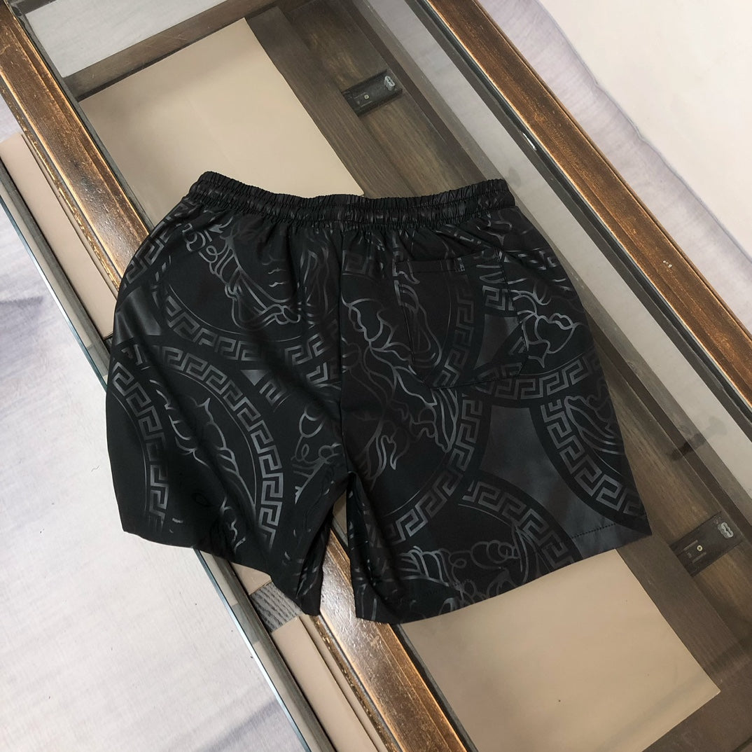 Versace black patterned shorts with elastic waistband and drawstring, full front view.