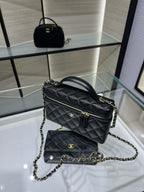 Black quilted Chanel shoulder handbag with top handle and gold-tone chain strap