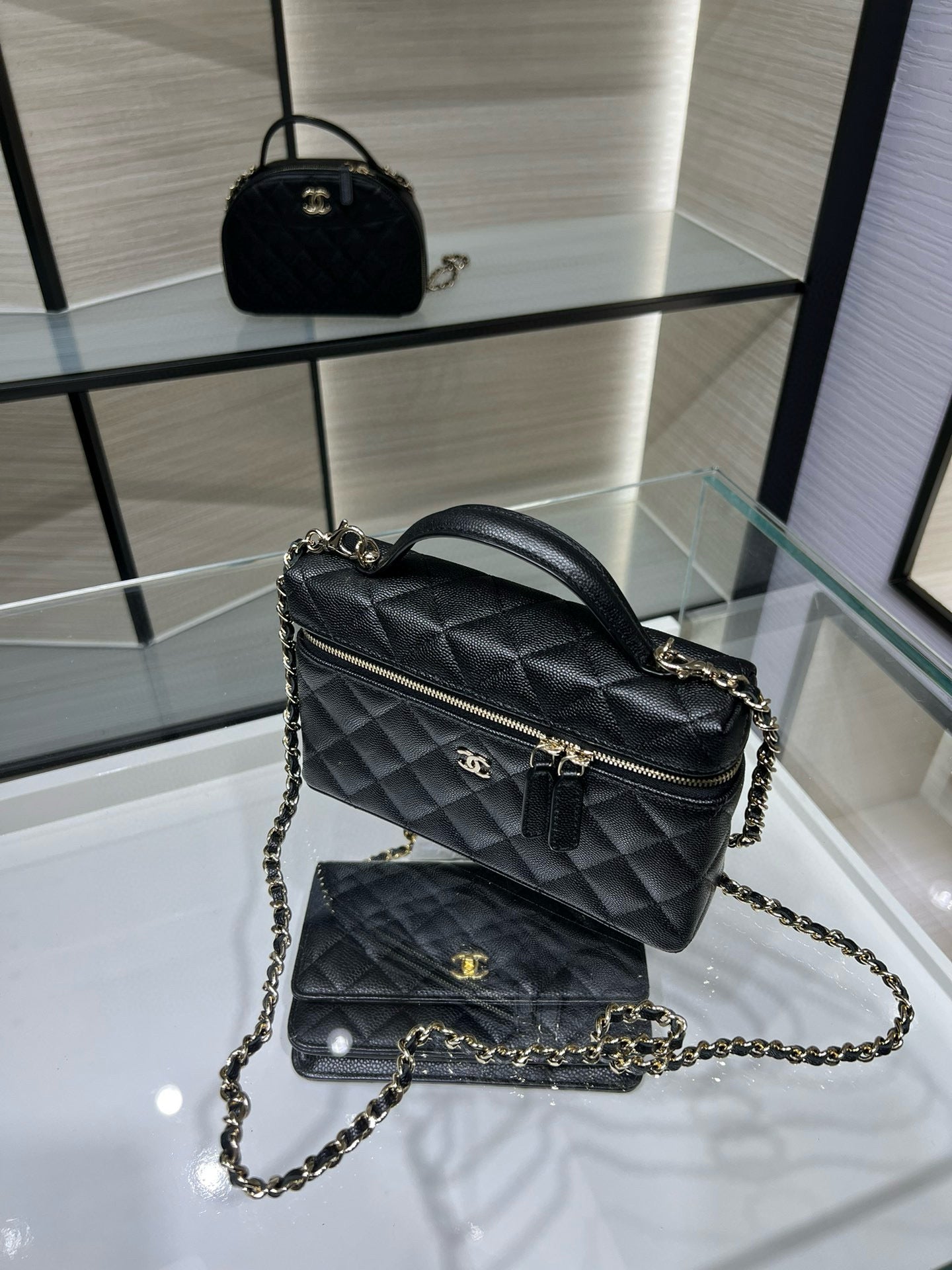 Black quilted Chanel shoulder handbag with top handle and gold-tone chain strap