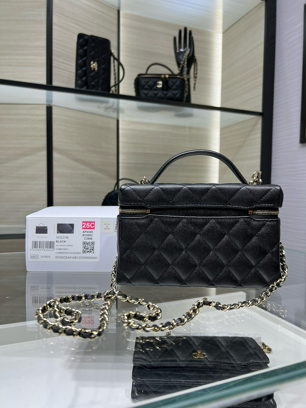 Black quilted Chanel satchel handbag with top handle, chain strap, and front flap