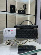 Black quilted Chanel satchel handbag with top handle, chain strap, and front flap