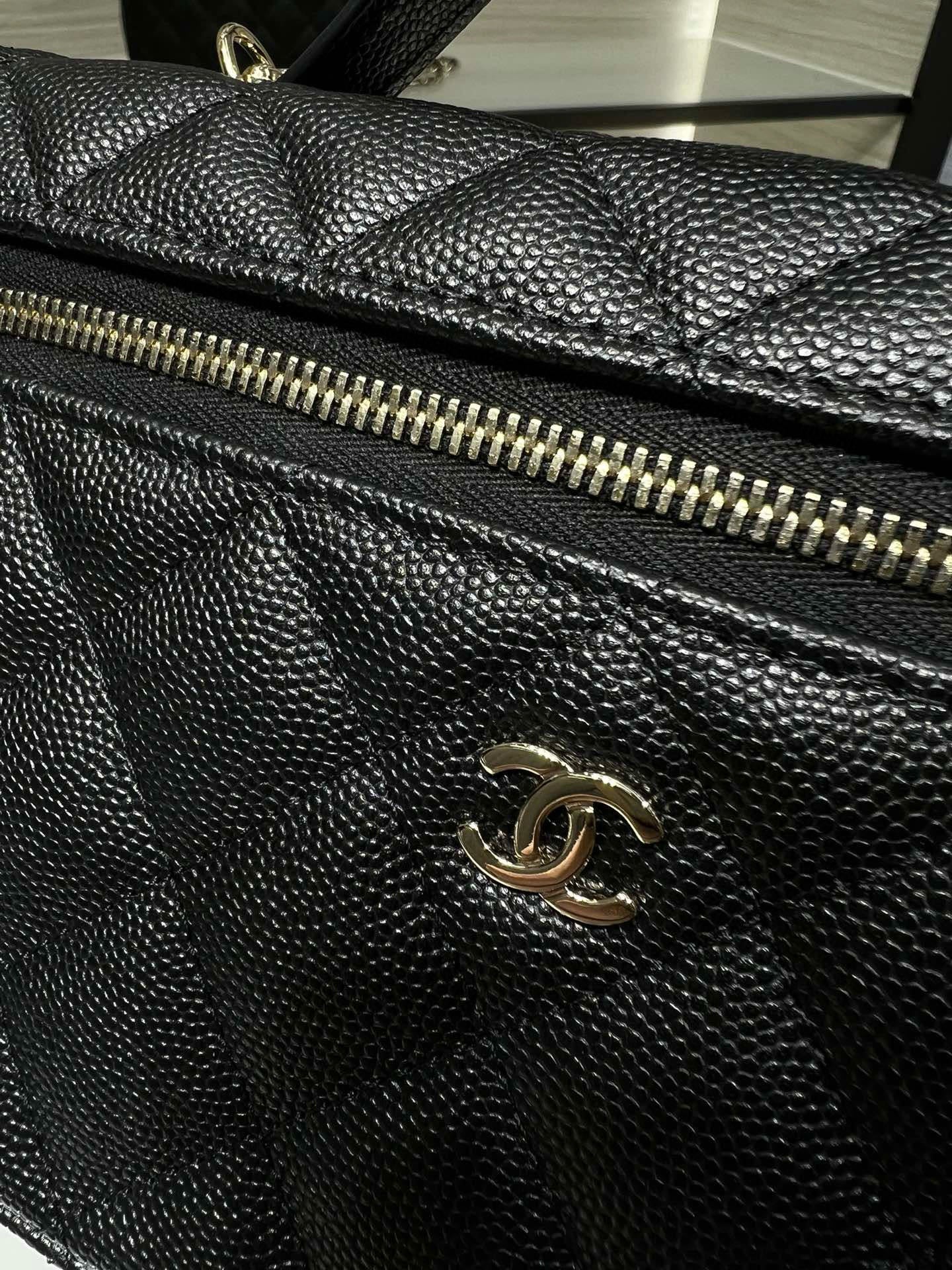 Close-up of black quilted Chanel handbag with gold-tone zipper and flap detail