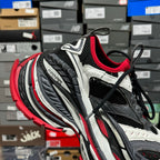 Chunky sneaker with black mesh, white overlays, red inner lining, and lace-up closure