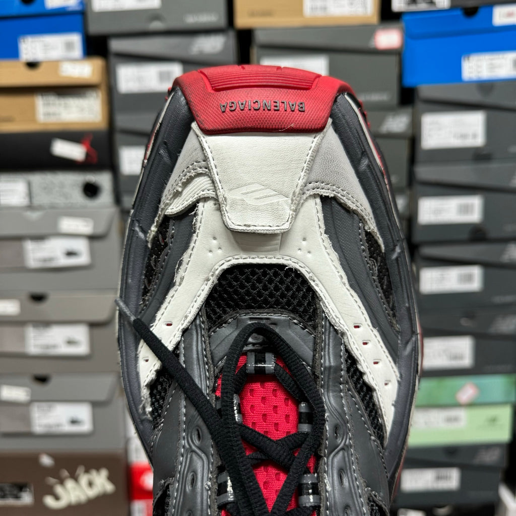 Shoe heel and collar with red lining, black straps, and white leather overlays