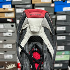 Shoe heel and collar with red lining, black straps, and white leather overlays