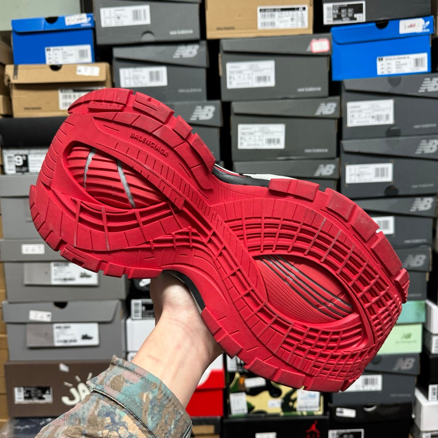 Red outsole of chunky sneaker with deep tread pattern