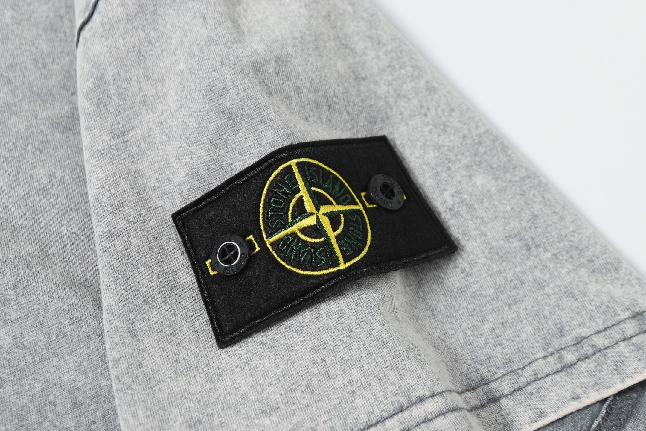 Stone Island logo patch on light gray sleeve