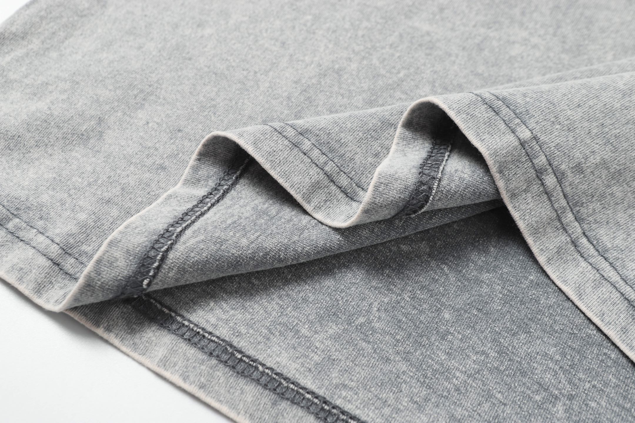 Light gray T-shirt sleeve seam and cuff stitching detail