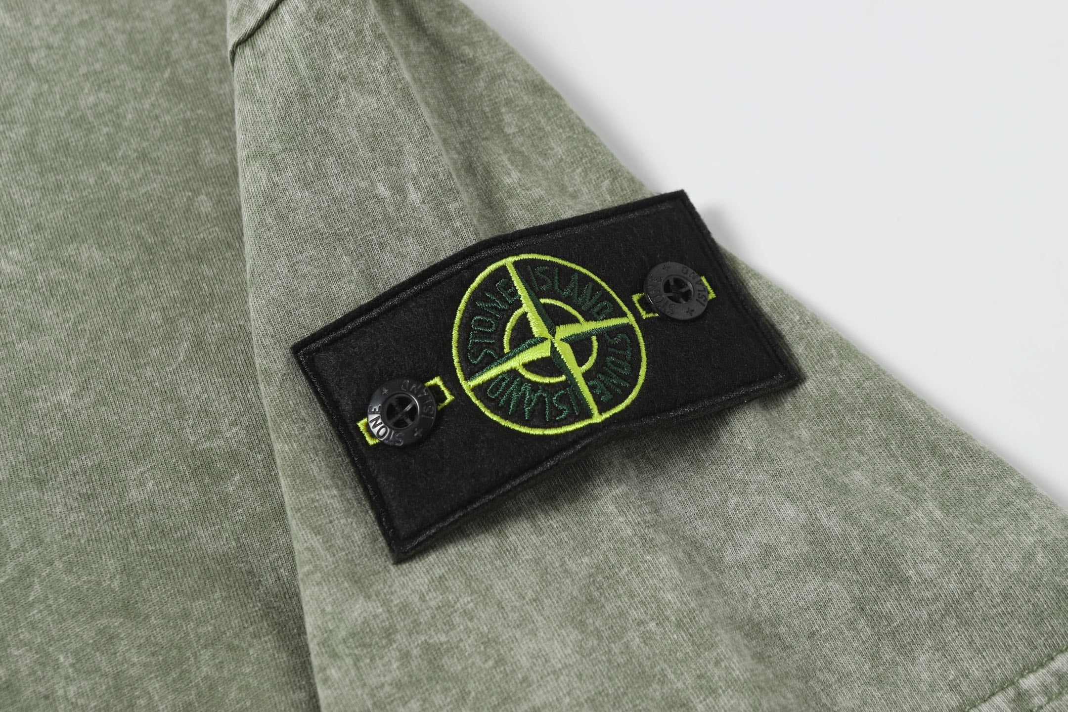 Stone Island T-shirt in sage green with black chest patch and neon green emblem