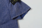 Blue T-shirt hem with logo patch corner and folded sleeve cuff.