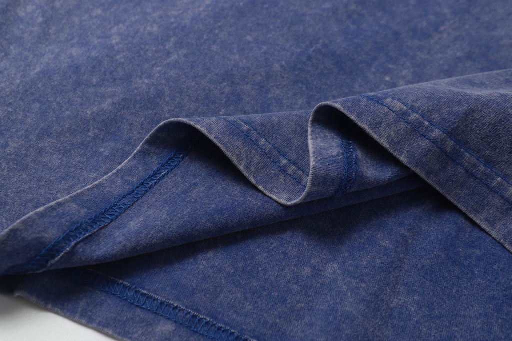 Blue T-shirt fabric folds with smooth knit texture.