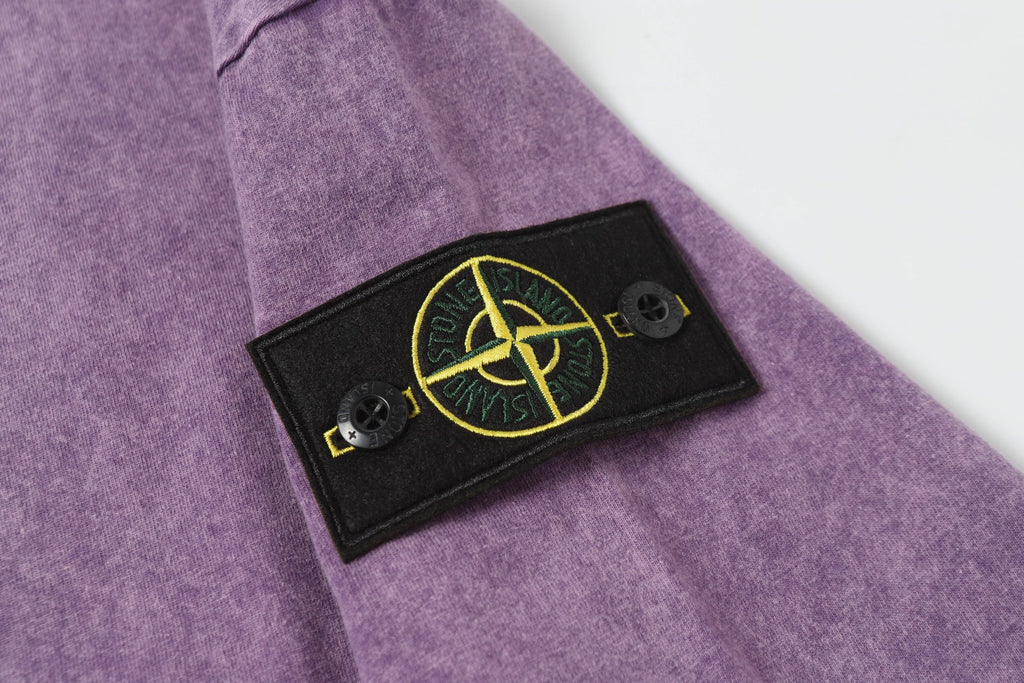 Stone Island T-shirt with black logo patch and yellow emblem on sleeve.