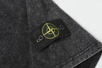 Dark charcoal T-shirt chest patch with yellow emblem and two visible buttons