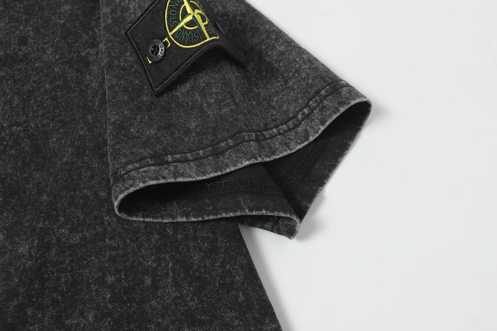 Dark charcoal T-shirt hem and sleeve cuff detail, speckled fabric texture