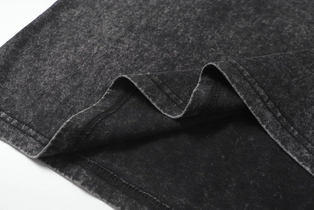 Dark charcoal T-shirt fabric fold and seam detail, speckled texture