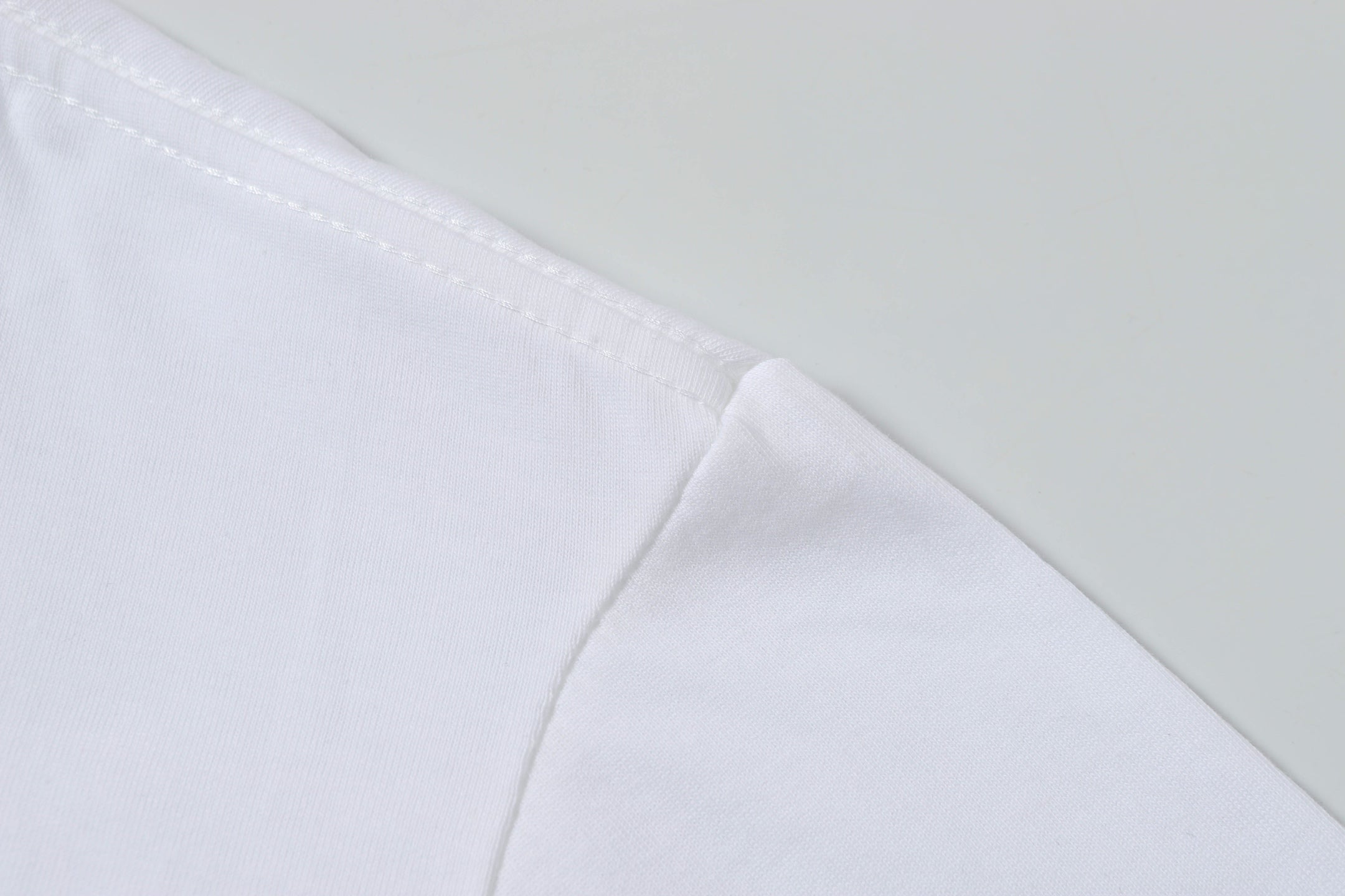 White Stone Island T-shirt fabric with stitched seam at shoulder.