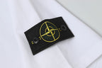 White Stone Island T-shirt sleeve patch with gold emblem on black fabric.